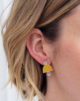A lady with short blonde hair models a close up, side view of the Deuce studs in chartreuse.
