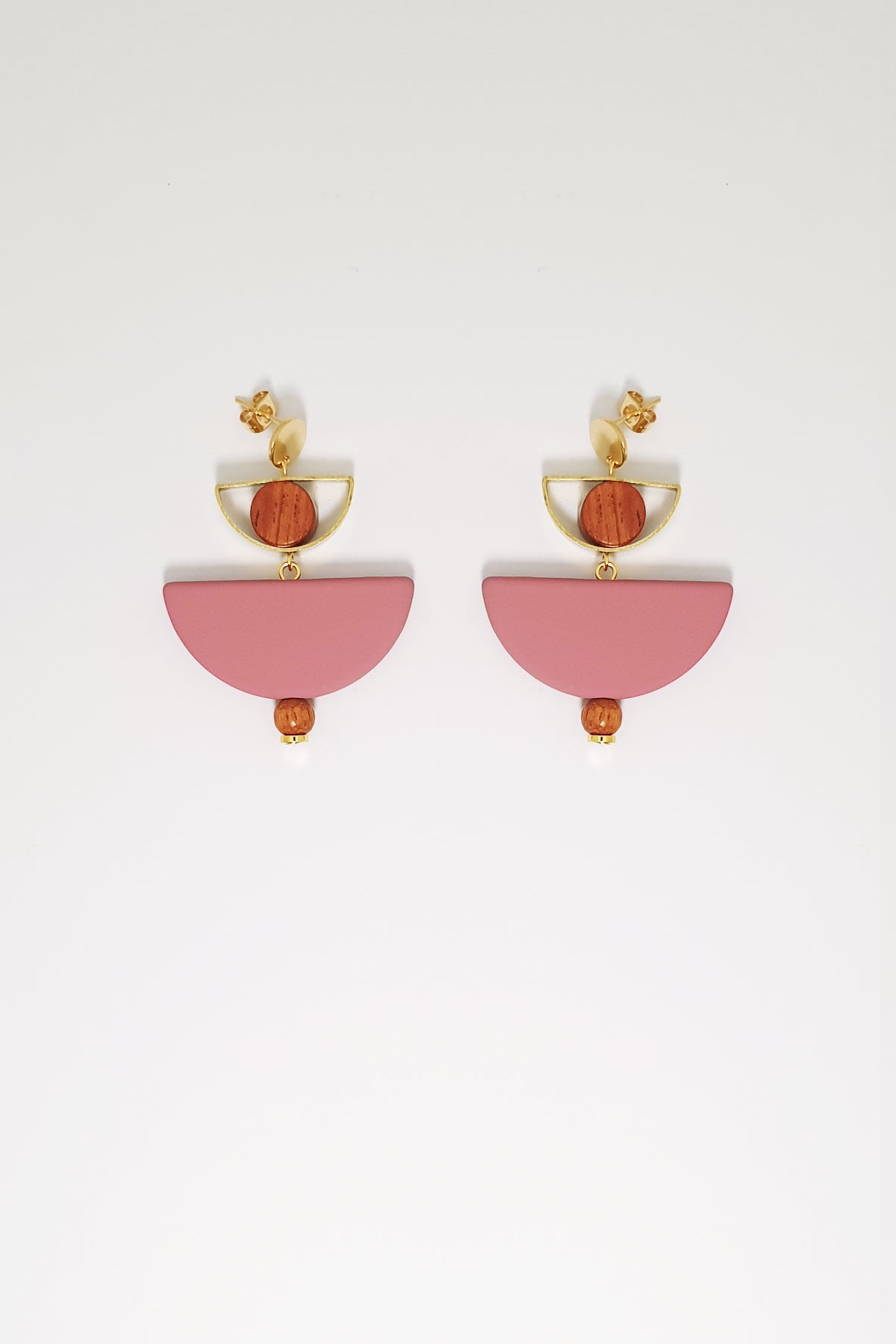  A pair of stud dangle earrings sit against a white background. They feature a small half circle brass piece with a wooden circle bead enclosed, below this hangs a grape D shape bead followed by a small wooden bead and a tiny gold bead.