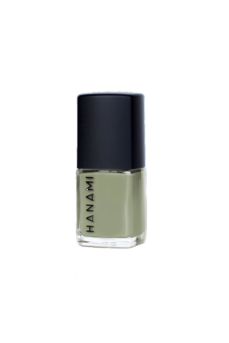 A bottle of nail polish in sits against a white background. It features a cubed glass bottle with the words HANAMI written in black uppercase text along one side and has a black cube-shaped lid. It is filled with a sage green nail polish.