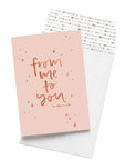 A pale pink card with the message 'from me to you' is sitting on a white background. The card uses rose gold script font and has hand drawn stars around it. There is a white envelope behind the card which has an arrow pattern design inside.
