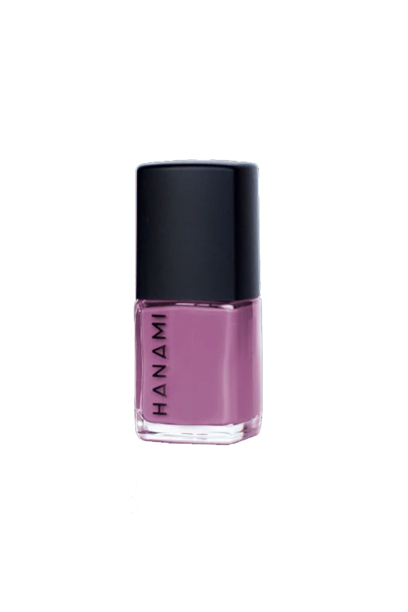 A bottle of nail polish in sits against a white background. It features a cubed glass bottle with the words HANAMI written in black uppercase text along one side and has a black cube-shaped lid. It is filled with a violet purple nail polish.