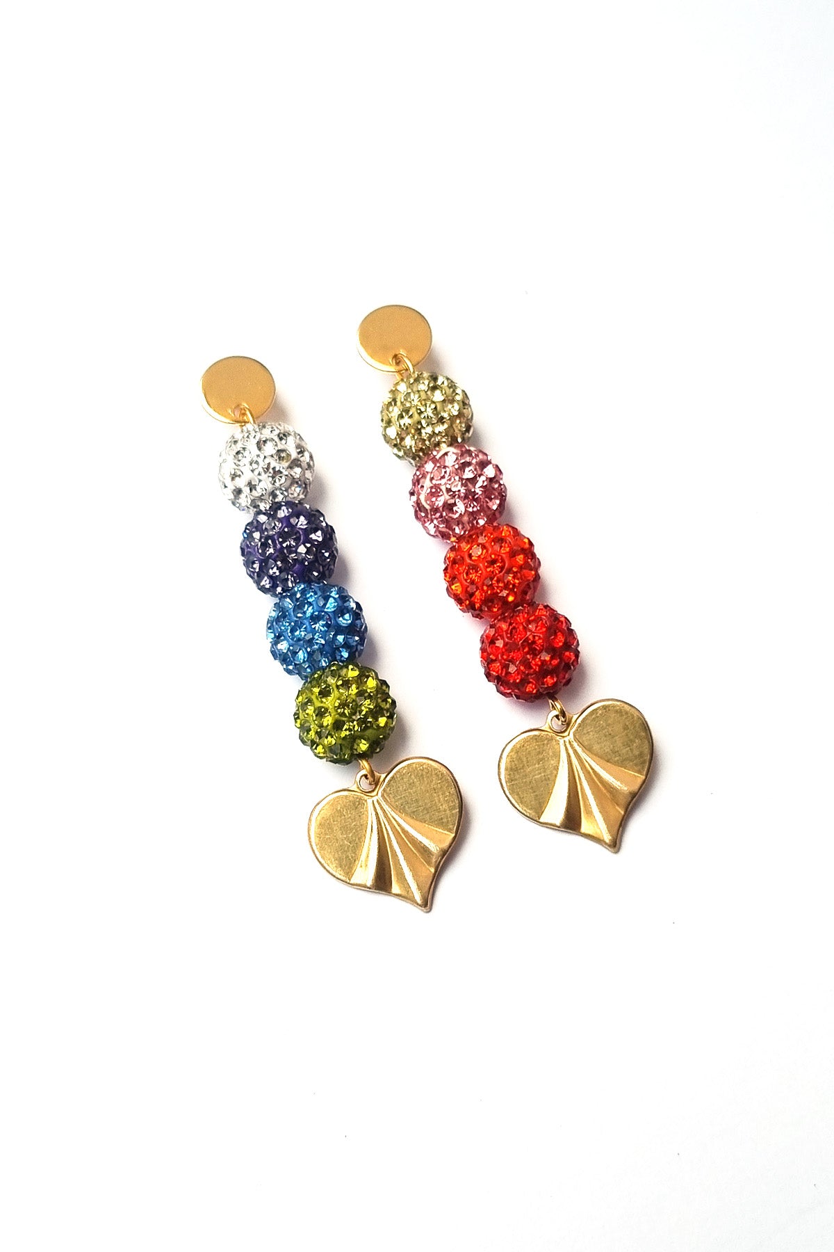 A pair of statement stud dangle earrings sit against a white background. They feature a gold stud top. One earring has a row of sparkly balls in white, purple, light blue and green, followed by a brass heart piece. The other earring has a light green, light pink, light red, and deep red sparkly ball, followed by a brass heart. 