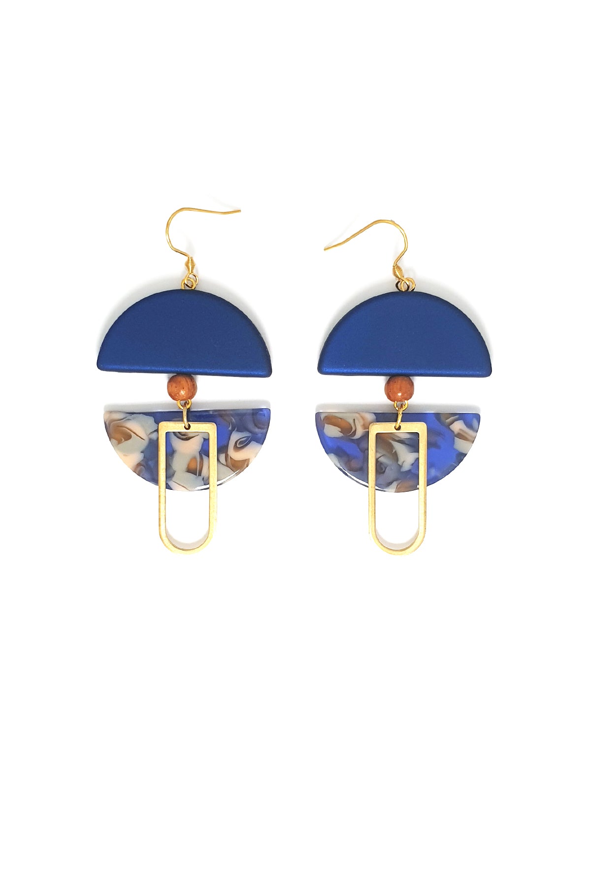 A pair of dangle earrings with a hook sit against a white background. They feature a blue arch shaped bead, a small wooden bead, a blue acrylic half circle, and an elongated D shape brass piece.