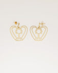 A pair of statement gold plated brass earrings sit against a white background. They feature a small gold stud top, and a custom brass geometric shape that resembles a lady with curly hair with her arms above her head in the shape of a heart.